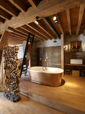 landelijke badkamer met koperen badkuip in de oude koekjesfabriek Parein